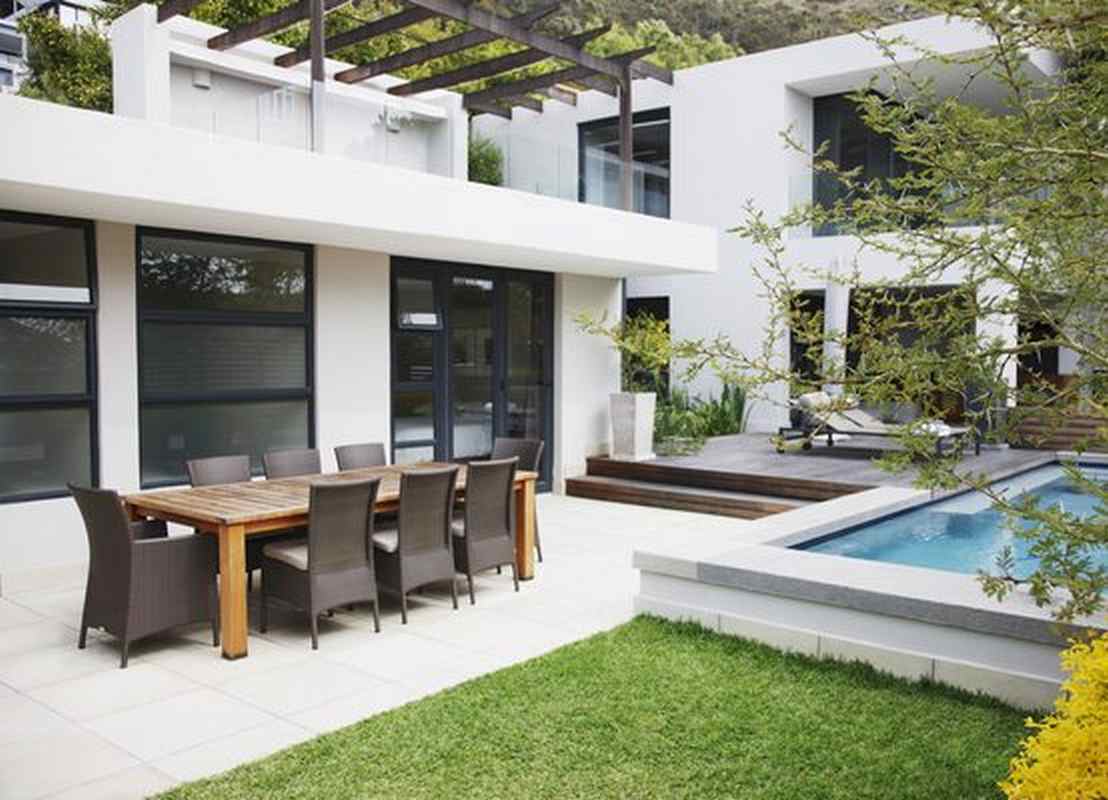 Ventanas correderas gran formato en salón moderno con acceso a terraza y piscina